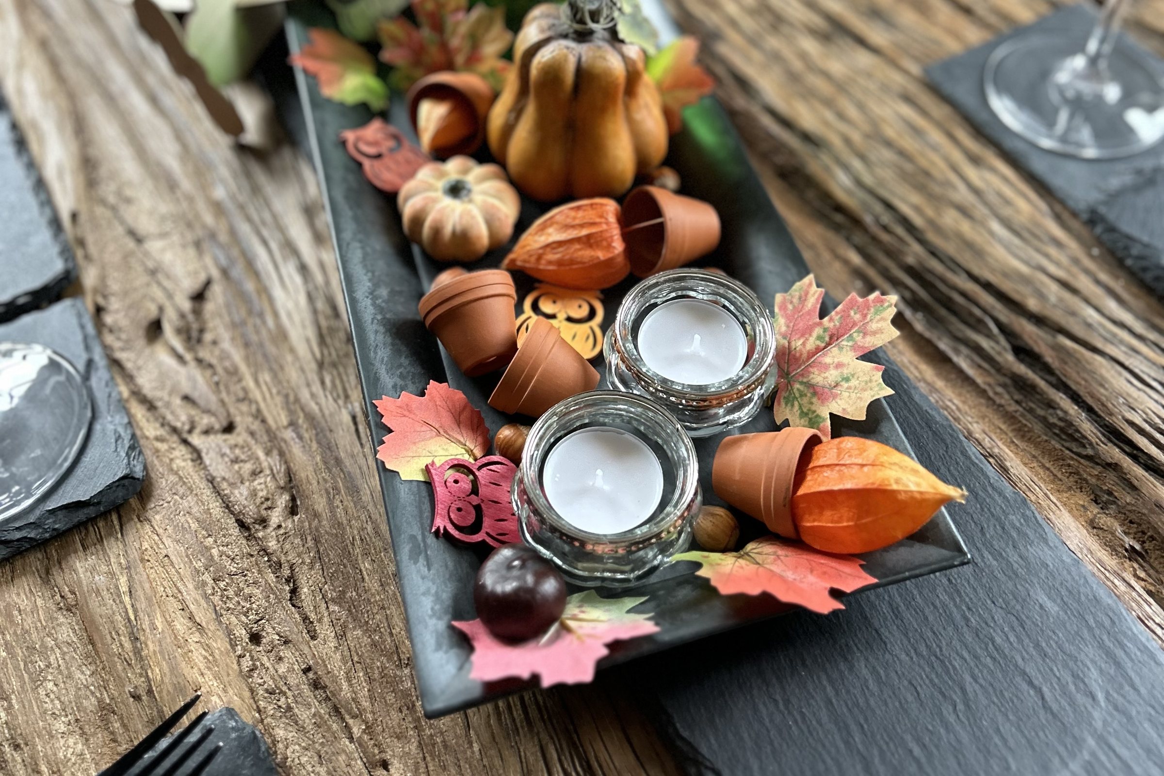 Herbstlich dekorierte Tafel mit Teelichtern und Laub im Servus Anni
